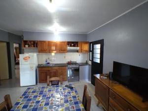 a kitchen with a table and a white refrigerator at LA CASITA DEL TATA in Jardín América