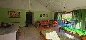 a living room with green walls and a couch at Akivai Lodge Ua-Pou in Hakamui