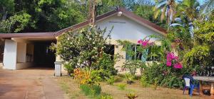 uma casa com uma mesa e flores à sua frente em Akivai Lodge Ua-Pou em Hakamui