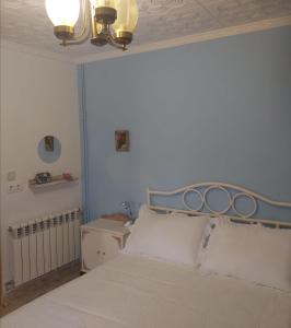 een bed met een blauw hoofdeinde in een slaapkamer bij ALOJAMIENTO TURISTICO LAS SOLANERAS in Solana del Pino