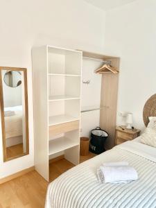 - une chambre avec un lit blanc et un miroir dans l'établissement Apartment Rosario in Malaga center, à Malaga