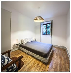 1 dormitorio con 1 cama y luz colgante en Quinta da Regadas, en Arouca
