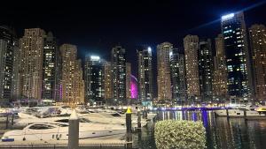 uma grande cidade à noite com barcos na água em Stay in heart of Dubai Marina walk to JBR beach no Dubai