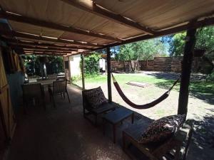 een veranda met een hangmat en een tafel en stoelen bij La Floresta in La Floresta