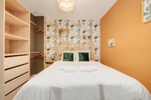 a bedroom with a large white bed with green pillows at L'Elégance du centre - Nancy Gare Congrès - PARKING - T3 in Nancy