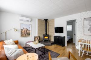 een woonkamer met een bank en een houtkachel bij Repère d'Eastman (accès au lac/foyer/randonnée) in Eastman