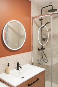La salle de bains est pourvue d'un lavabo et d'une douche avec un miroir. dans l'établissement L'Elégance du centre - Nancy Gare Congrès - PARKING - T3, à Nancy