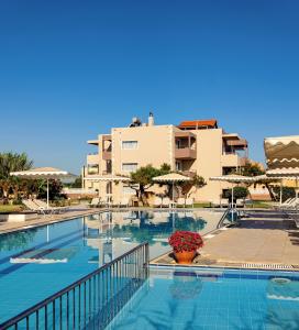 a swimming pool with a vase of flowers and a building at Matzi Hotel Apartments in Gerani