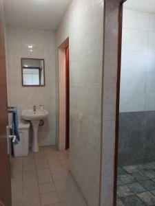 a bathroom with a sink and a glass shower door at Oasis Appartement in Blue Bay