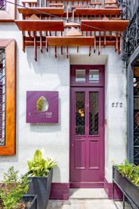 una puerta púrpura en el lateral de un edificio en Hotel Casa do Bispo, en Manaus