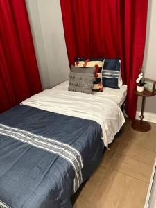 a small bedroom with a bed with red curtains at Cozy Home in the Heart of Jackson/UMMC Hospital in Jackson