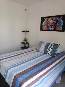 un dormitorio con una cama con una pintura de un león en AQUAVALE - Apartamento Vacacional en Girardot, en Girardot