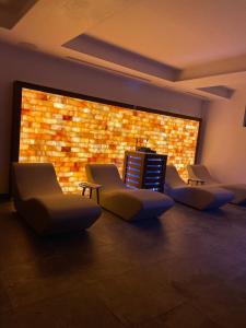 een kamer met 4 stoelen en een bakstenen muur bij Palace Hotel & SPA La CONCHIGLIA D' ORO in Vicenza