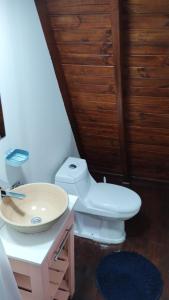 uma casa de banho com um WC branco e um lavatório. em Alas Cabañas em El Bolsón