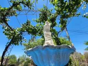 a statue of a vase in front of a wheel at Departamento Blach in Cafayate