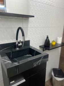 ein schwarzes Waschbecken in einer Küche mit einer Theke in der Unterkunft Chacara em Socorro- SP próx ao centro, com piscina e area gourmet in Socorro