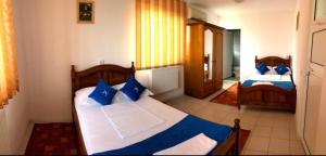 um quarto com 2 camas e almofadas azuis em Hanul Pescarilor em Mila Douazeci si Trei