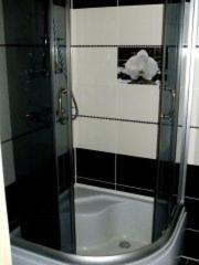 a shower with a glass door in a bathroom at Apartamenty Kharkovskaya in Sumy