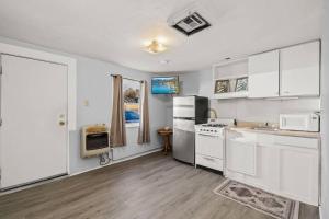 a kitchen with white cabinets and white appliances at Charming retro property! in Sparks