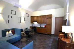 ein Wohnzimmer mit einer blauen Couch und eine Küche in der Unterkunft ARCApartaments in Vercelli
