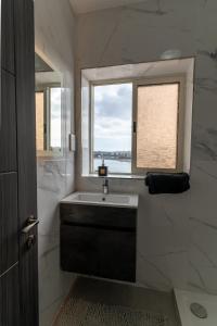 a bathroom with a sink and a window at Luxurious Beach Apartment in Birżebbuġa