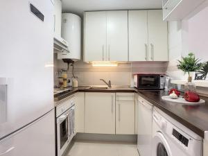 a white kitchen with white cabinets and a dishwasher at Modern apartment Bodrum in Bodrum City