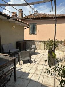 un patio con sillas y mesas y un edificio en DOMUS TUSCIA APARTMENTS Via Estrema 2, en Viterbo