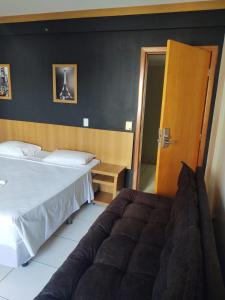 a bedroom with two beds and a couch in it at Golden Dolphin Grand Hotel in Caldas Novas