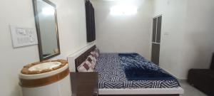 une petite chambre avec un lit et un miroir dans l'établissement Vinayak home stay, à Ujjain