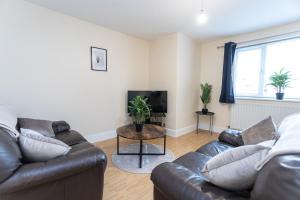 a living room with two couches and a tv at May Disc - Long Stay - Contractors in Swindon
