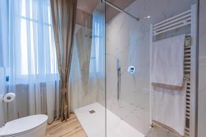 ein Bad mit einem WC und einer Glasdusche in der Unterkunft Saint Paul Deluxe Apartments, Alba in Alba