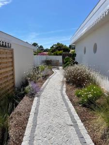 a stone walkway next to a white building at Les Lodges de Saint Brice 2 in Arès