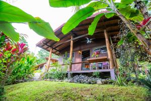 a guest house in the middle of a garden at Toucan Villa -riverfront With Pool & Near A Beach in Uvita