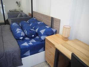 a bedroom with a bed with blue pillows on it at Cozy room, BKK for short and long term rentals, 10mins walk to BTS, 25mins taxi to DMK airport in Ban Ko