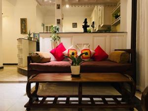 a living room with a couch with colorful pillows at Winston Dutch Canal Villa Guest House in Negombo