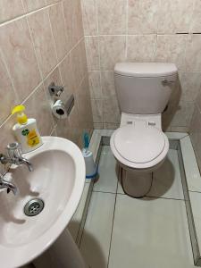 a bathroom with a toilet and a sink at 56 Archer Crescent Mainhouse in Durban