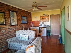 a living room with a couch and a brick wall at Garingboom Guest Farm in Springfontein