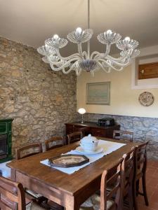 een eetkamer met een tafel en een kroonluchter bij Art Apartment Agriturismo il Vecchio Merlo in Larciano