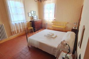 a bedroom with a bed and a dresser and windows at Art Apartment Agriturismo il Vecchio Merlo in Larciano