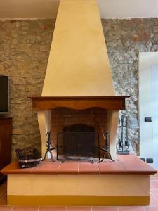 a brick fireplace with a stove in a room at Art Apartment Agriturismo il Vecchio Merlo in Larciano