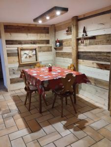 una mesa y sillas en una habitación con paredes de madera en Botton d'oro en Campitello di Fassa