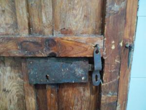 una vieja puerta de madera con un pestillo de metal. en Casita de la Alegría en La Puerta de Segura
