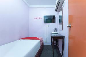 a bedroom with a bed and a table and a tv at Apollo Hotel Johor Bharu in Johor Bahru
