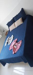 a blue bed with two pairs of shoes on it at Apê Aconchegante in Recife