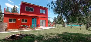 a red house with a table in a yard at Casa quinta 281 in La Plata