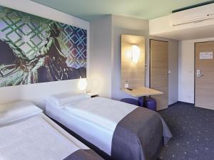 a hotel room with a bed and a desk at B&B Hotel Dortmund-City in Dortmund