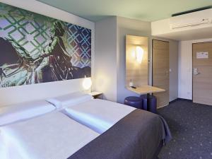 ein Hotelzimmer mit einem Bett und einem Gemälde an der Wand in der Unterkunft B&B Hotel Dortmund-City in Dortmund