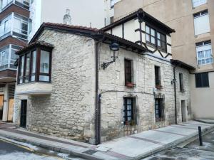 an old stone building on the side of a street at La antigua in Villarcayo