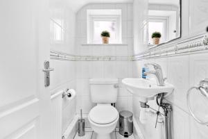 a white bathroom with a toilet and a sink at Bramcote Lane Spacious 5 BR House in Nottingham