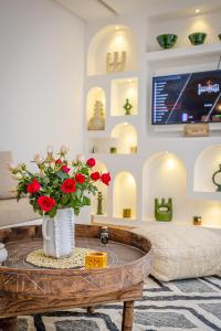 een kamer met een tafel met een vaas met rode bloemen bij Riad Agan/Exclusive&New/Pool/Breakfast included in Marrakesh